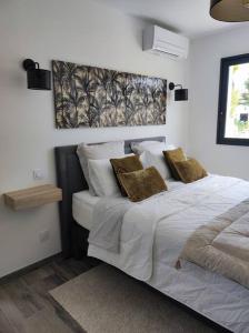 sypialnia z łóżkiem z białą pościelą i poduszkami w obiekcie Joli havre de paix w mieście Prades-le-Lez