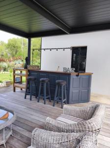 un patio con bar y taburetes en una terraza en Joli havre de paix en Prades-le-Lez