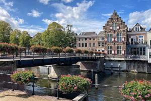 a bridge over a river with flowers and buildings at B and B Suite No.3 in Gorinchem