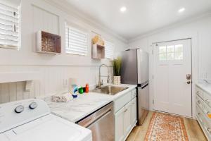 a white kitchen with a sink and a refrigerator at Jewel's Cottage in Demere Park