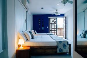 a bedroom with a large bed with a blue wall at 7CN-3 CASA DE 7 HABITACIONES EN EL CENTRO HISTORICO in Cartagena de Indias