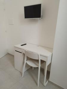 a white desk with a tv on a wall at Le stanze del Maestro in Matera