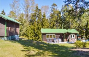 une cabane en rondins avec un toit vert et une cour dans l'établissement Awesome Home In Nynshamn With Sauna, à Nynäshamn
