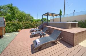 a deck with lounge chairs and a bench on a roof at Holiday house SEA & SUN RESIDENCE in Rasopasno