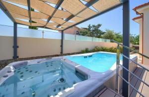 a hot tub on a balcony with a pergola at Holiday house SEA & SUN RESIDENCE in Rasopasno