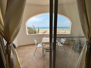 ein Esszimmer mit einem Tisch und Strandblick in der Unterkunft sea View Nautilus free wi-fi Sal Rei in Sal Rei