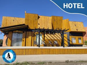 a building with a wooden facade with chairs in front at Hotel Aconchego in Urubici