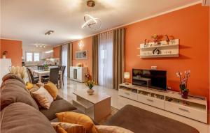 a living room with an orange wall at Cozy Home In Skatari With Outdoor Swimming Pool in Šikići