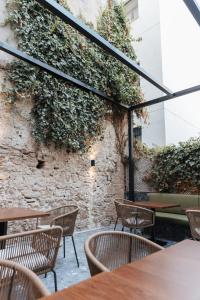 a patio with tables and chairs and a brick wall at Boutique Hotel OLOM - Adults recommended in Cádiz
