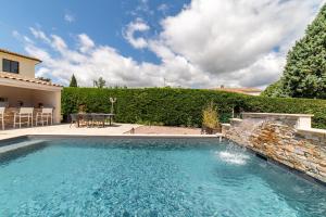 einen Pool mit Wasserfall im Hof in der Unterkunft Grand studio climatisé avec piscine - 3 étoiles in Villemoustaussou