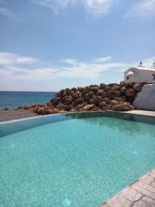 a swimming pool with the ocean in the background at Axiotheaton Villas in Pefki Rhodes