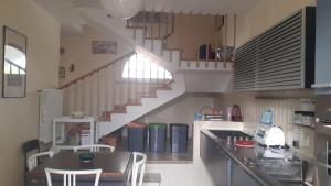 eine Küche mit einer Treppe mit einem Tisch und Stühlen in der Unterkunft Relais dei due Mari in Carmiano
