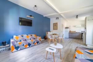 ein Wohnzimmer mit einem Sofa und einem Tisch in der Unterkunft Grand studio climatisé avec piscine - 3 étoiles in Villemoustaussou