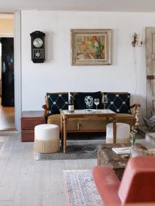 錫姆里斯港的住宿－Sköllengården，客厅配有沙发和墙上的时钟
