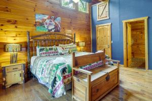 een slaapkamer met een bed en een houten muur bij Pigeon Forge Cabin with Pool Table and Deck Near Town! in Pigeon Forge