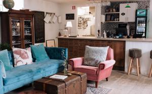 a living room with two blue couches and two pink chairs at Sköllengården in Simrishamn