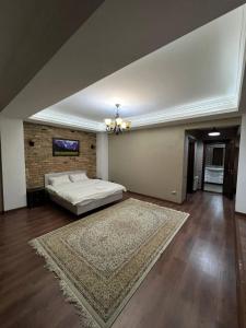 ein Schlafzimmer mit einem Bett und einer Ziegelwand in der Unterkunft Lite Guest House in Bischkek