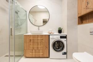 a bathroom with a washing machine and a mirror at Flatbook - Seaside Apartments Porto Gdańsk in Gdańsk