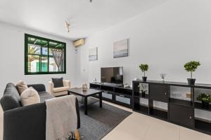 a living room with a couch and a tv at Casa Mon in Costa Teguise