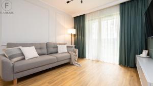 a living room with a couch and a window at Flatbook - Seaside Apartments Porto Gdańsk in Gdańsk