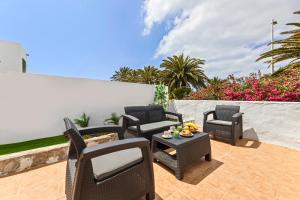 a patio with chairs and a table with fruit on it at Casa Mon in Costa Teguise