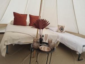 a room with two beds and a table with vases at Camping les lodges du Tarn in Mostuéjouls