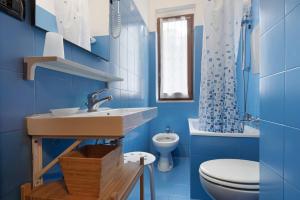 a blue bathroom with a sink and a toilet at Appartamento Monolocale Moneglia 25 in Moneglia +15 photos
