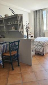 een kamer met een tafel, een stoel en een bed bij Le Provencou in Tulette