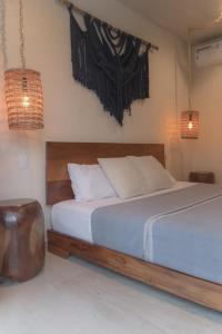 a bedroom with a bed with a wooden head board at Stylish Condo for 4 Rooftop & Pool Access in Tulum
