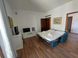 a bedroom with a bed and a flat screen tv at Maison Umberto I a Villasimius centro in Villasimius