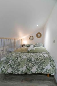 een slaapkamer met een bed met een groene en witte deken bij Résidence Le Celest - Appartements climatisés - Centre ville in Vichy