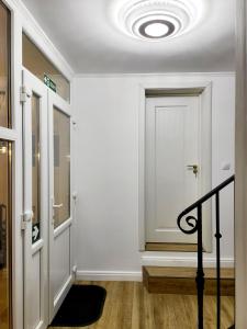 a hallway with a white door and a staircase at Double room - House of Chess in Satu Mare