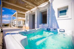 a jacuzzi tub in the backyard of a house at Phaos Santorini Suites in Imerovigli