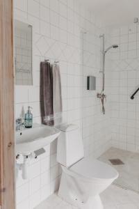 een witte badkamer met een toilet en een wastafel bij Sköllengården in Simrishamn