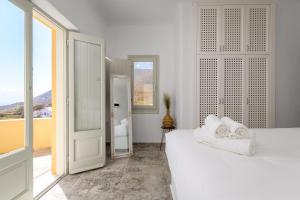 a white room with two beds and a bathroom at Geminos Complex Villas in Kamari