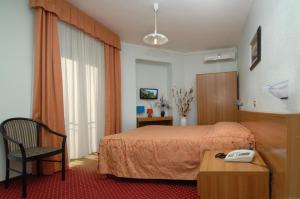 a hotel room with a bed and a phone on a table at Hotel Sorriso in Sanremo