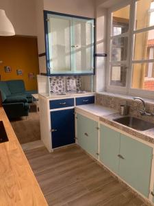a kitchen with blue and white cabinets and a sink at AIRAM Home ARAGON, 7 in Almansa