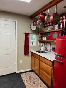 a kitchen with a red refrigerator and a sink at Casita with Swimming Pond & Sand Volleyball Access in Montgomery