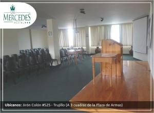 een kamer met stoelen en een tafel en een podium bij Hotel Las Mercedes in Trujillo