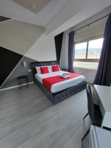 una camera da letto con un letto con cuscini rossi e una finestra di U Baruni B&B a Messina