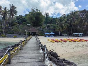 un chemin en bois menant à une plage avec des bateaux. dans l'établissement Samal Island Kembali Condo Resort, 