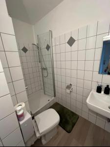 a bathroom with a toilet and a shower and a sink at Apartment City und Stadionnah I Privatparkplatz inklusive I in Dortmund