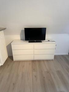 a white dresser with a television on top of it at Apartment City und Stadionnah I Privatparkplatz inklusive I in Dortmund
