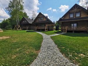 a gravel path leading to a log house at TOŁHAJÓWKA in Strzebowiska