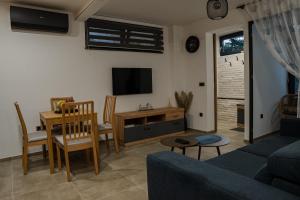a living room with a couch and a table and a tv at RITUAL Apartment - 20m from the sea in Lovran