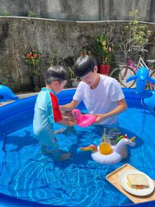 頭城的住宿－幸福海衝浪民宿，两个男孩在游泳池玩玩具