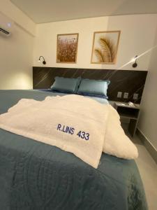 若昂佩索阿的住宿－Arpoar Suítes - Suíte 433，床上有一条白色的毯子