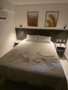 ein Schlafzimmer mit einem Bett mit einer Fliege darauf in der Unterkunft Arpoar Suítes - Suíte 433 in João Pessoa
