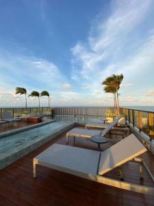 a balcony with tables and chairs and the ocean at Arpoar Suítes - Suíte 433 in João Pessoa