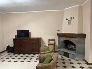 ein Wohnzimmer mit 2 Stühlen und einem Kamin in der Unterkunft Espoire casa sole vda morgex cir 109 in Morgex